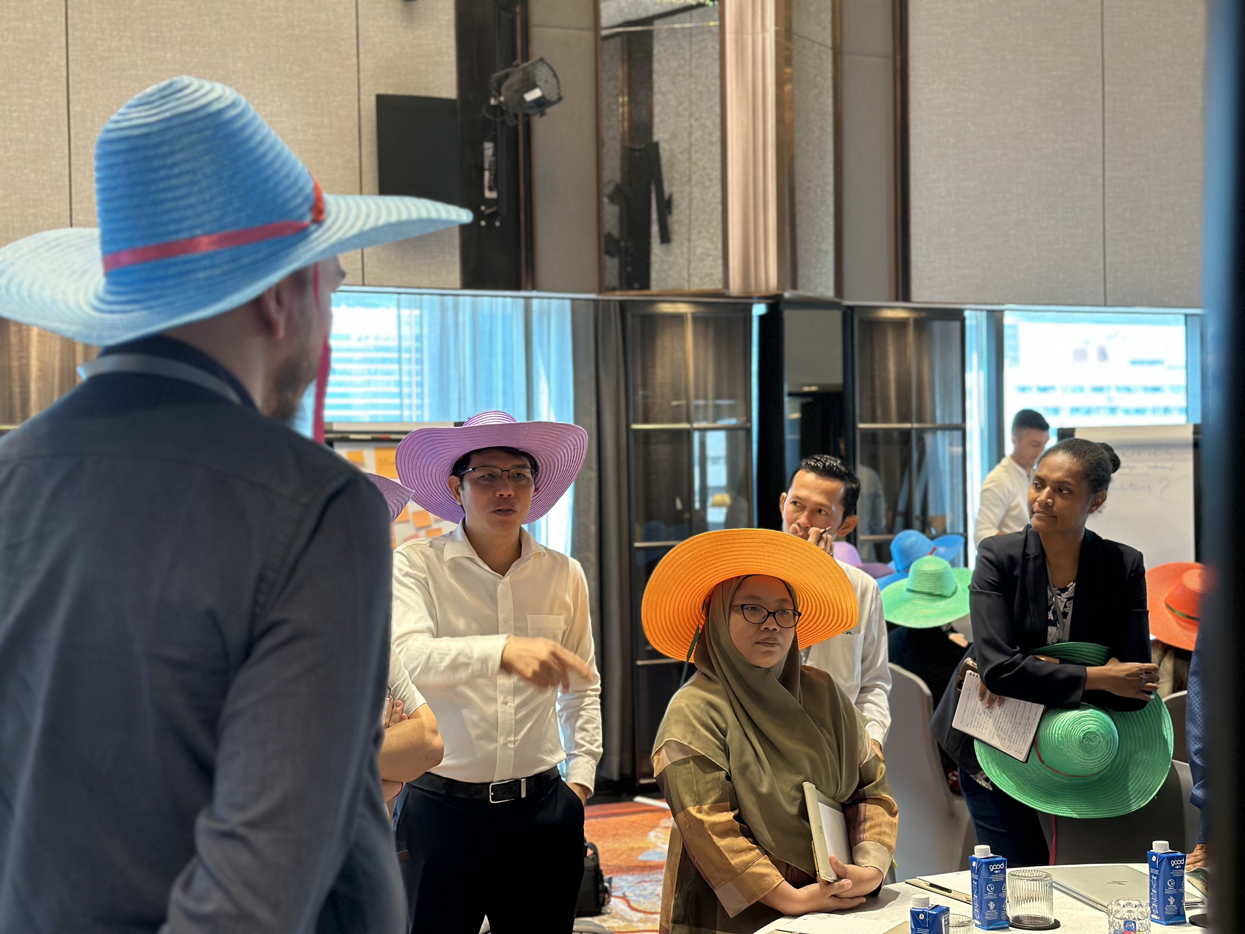 Participants wear colored hats in an exercise named thinking hats
