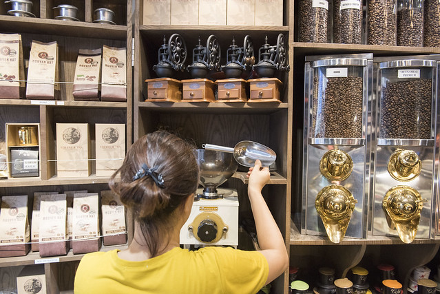 A coffee shop owner prepares beans for sale in Hanoi.