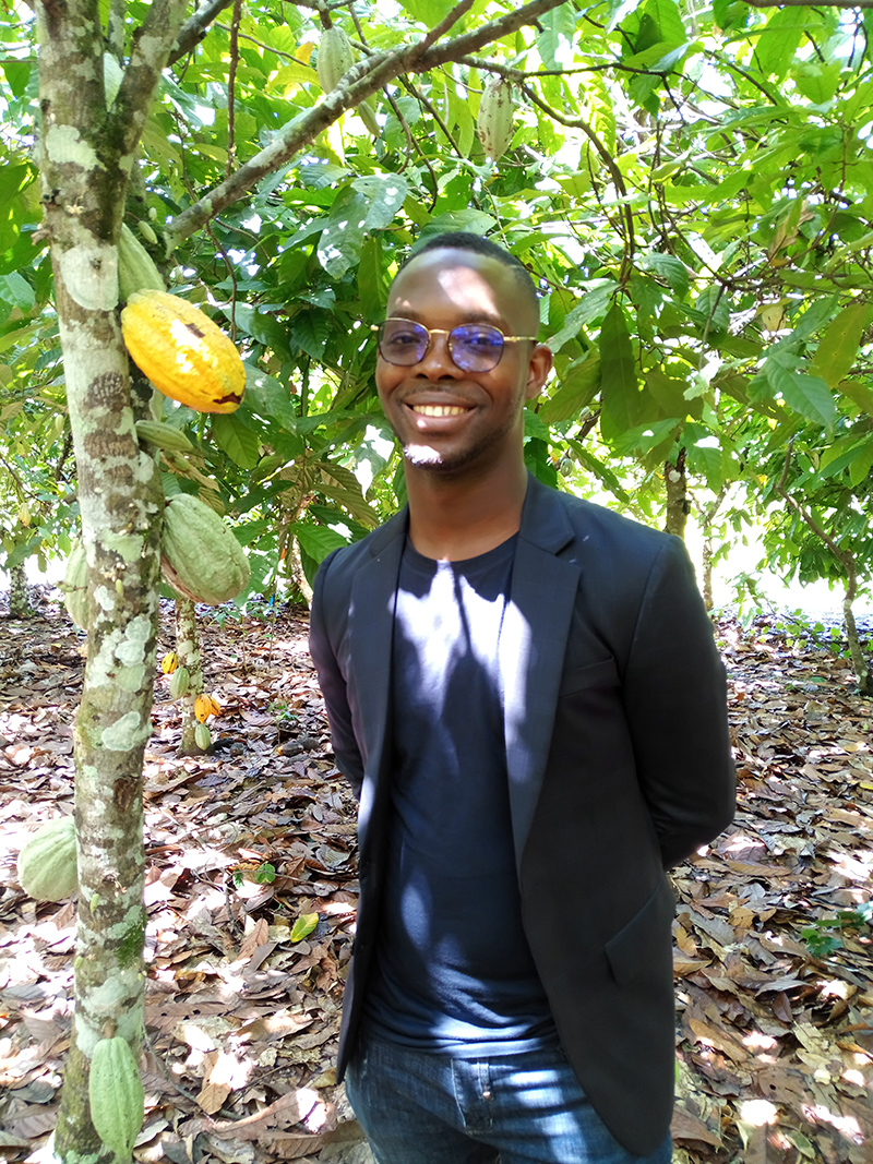 Jean Paul Aka next to a cocoa tree